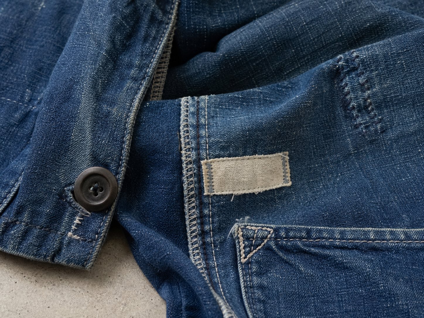Representative close view of garment stitching, hardware, and worn fabric